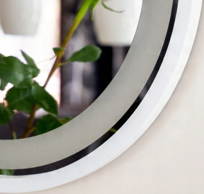 Fragment białej ramy lustra LED z podświetleniem.